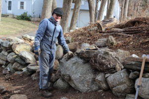 man next to rock wall